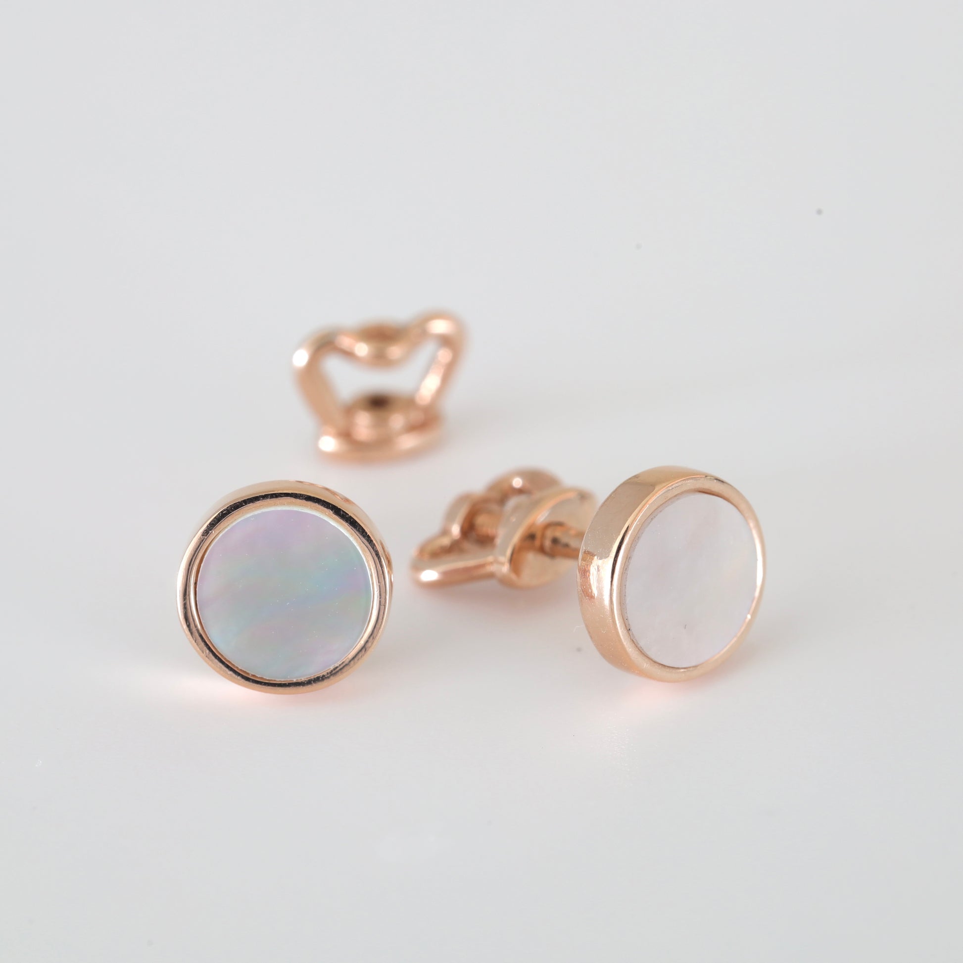 A pair of 14K (585) Rose Gold stud earrings with a secure threaded screw-back mechanism. Each earring holds a shimmering round mother-of-pearl stone in a warm gold frame, displayed on a neutral white background.