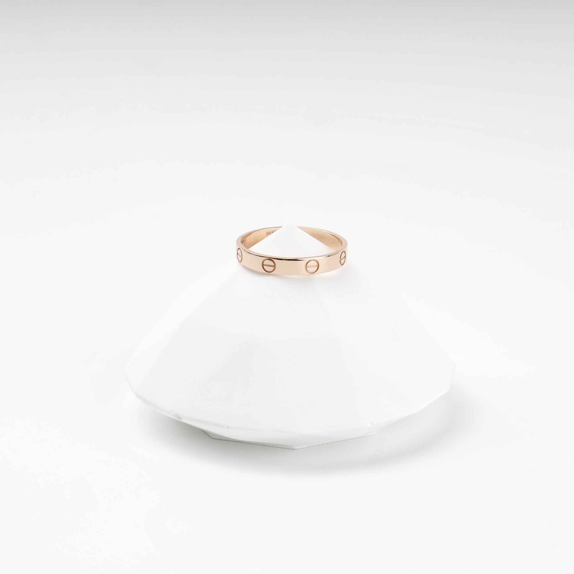 Rose gold band ring with evenly spaced screw details, angle — Kabluchka