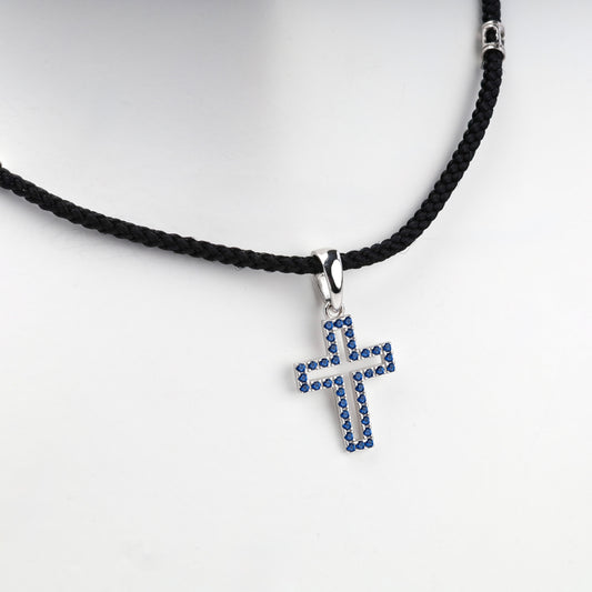 Rhodium-plated silver 925 cross pendant with blue cubic zirconia, angled view