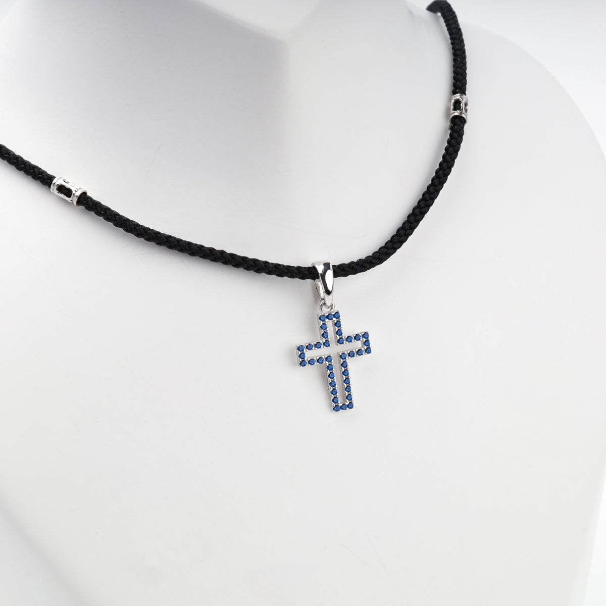 Rhodium-plated silver 925 cross pendant with blue cubic zirconia, back view