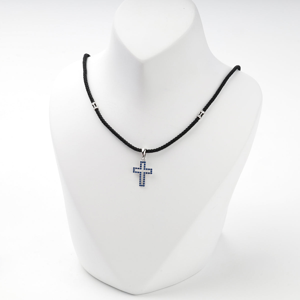 Rhodium-plated silver 925 cross pendant with blue cubic zirconia, side view