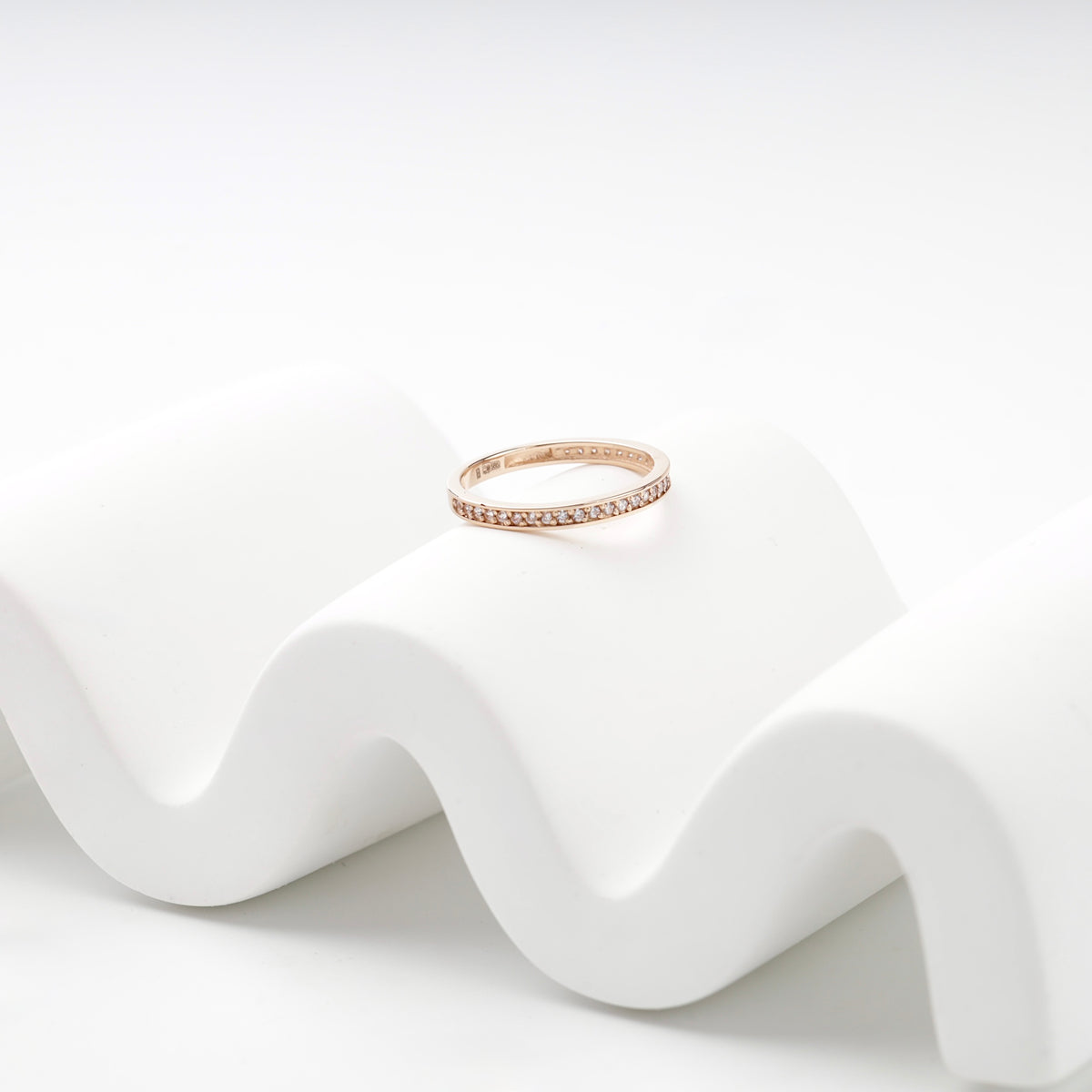 Slim rose gold cubic zirconia band ring on a white display — Kabluchka