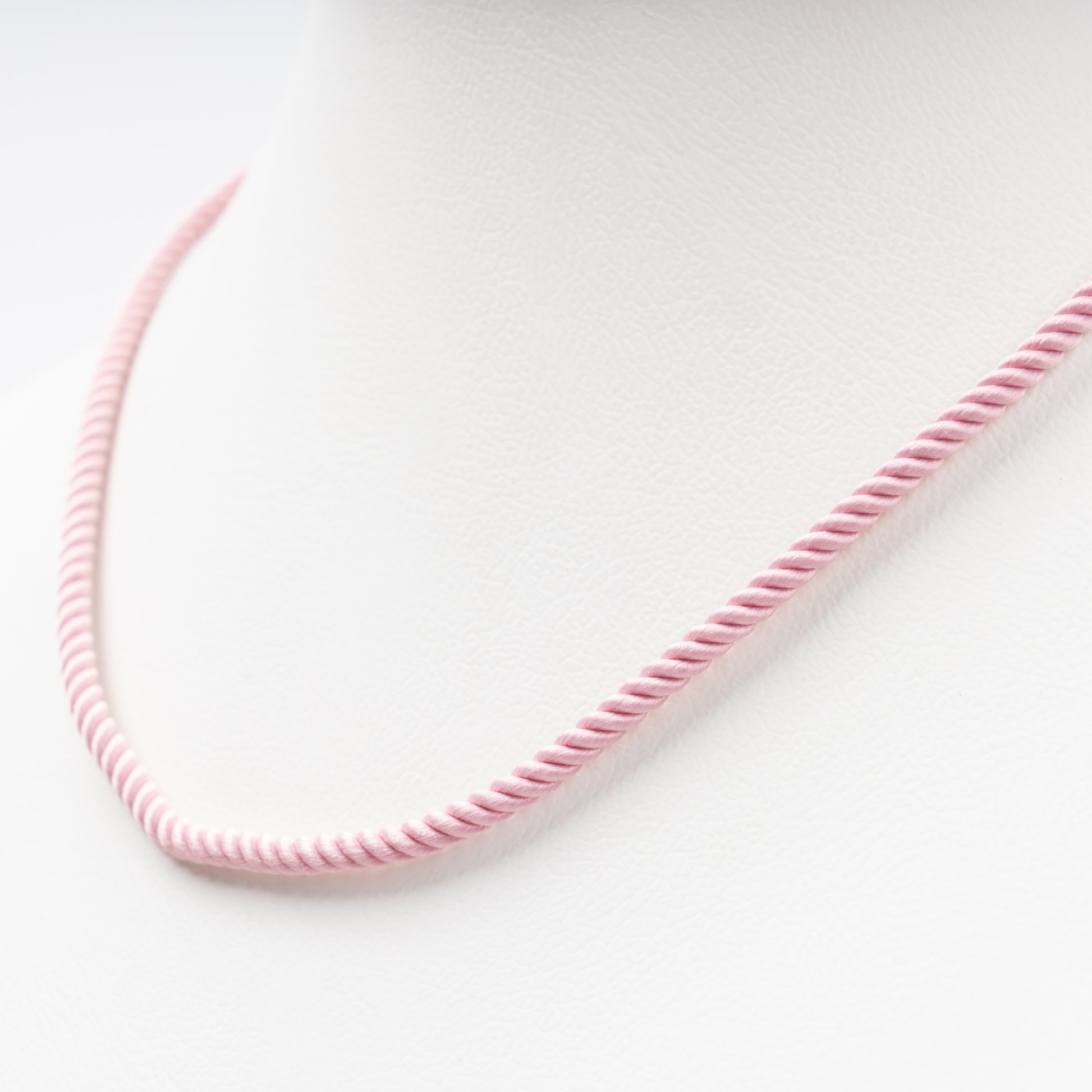 Sophisticated product - a pastel pink twisted silk cord necklace displayed on a white bust, 14K (585) Rose Gold lobster clasp and 585 hallmark.