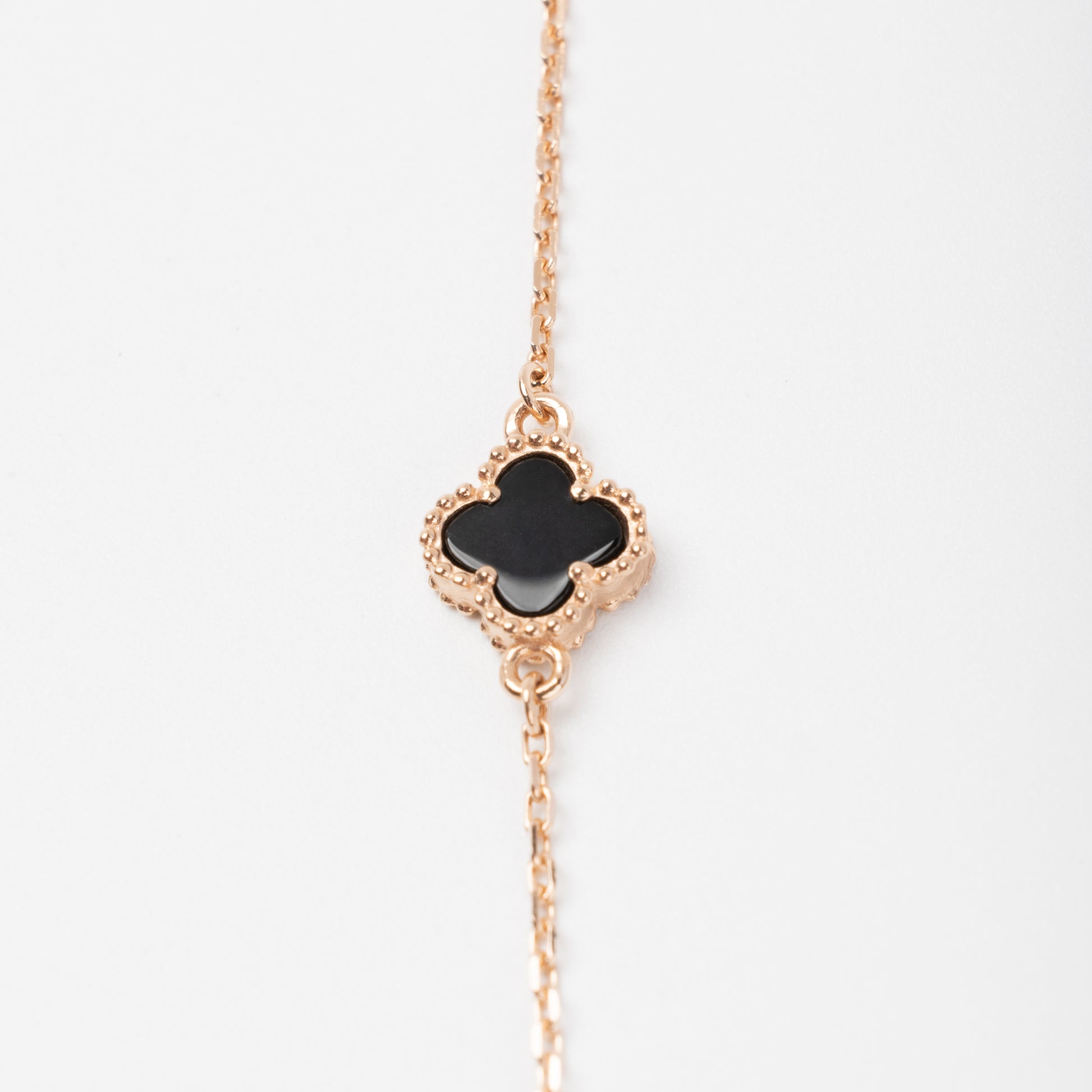 An exquisite 14K (585) Rose Gold bracelet featuring a black four-leaf clover centerpiece accented  on a delicate chain with an adjustable clasp.
