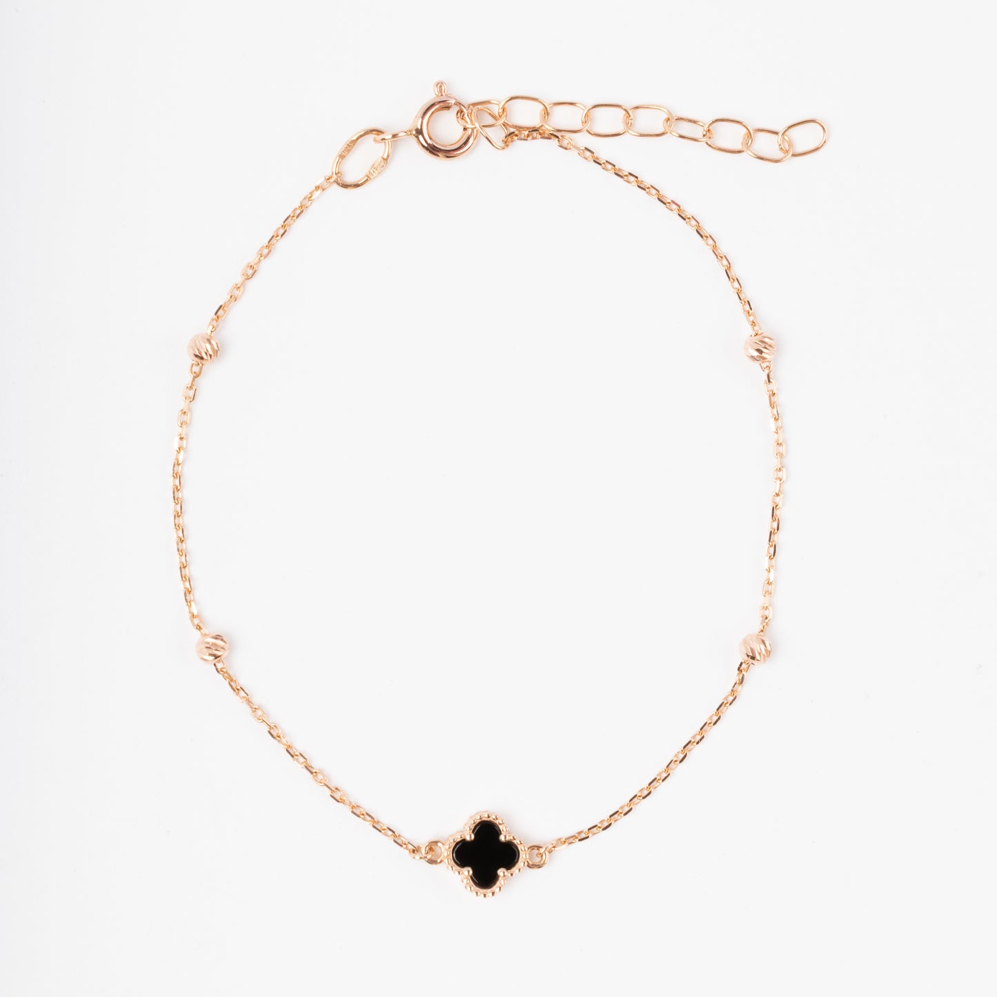 An exquisite 14K (585) Rose Gold bracelet featuring a black four-leaf clover centerpiece accented with four textured, cut-faced gold beads on a delicate chain with an adjustable clasp.