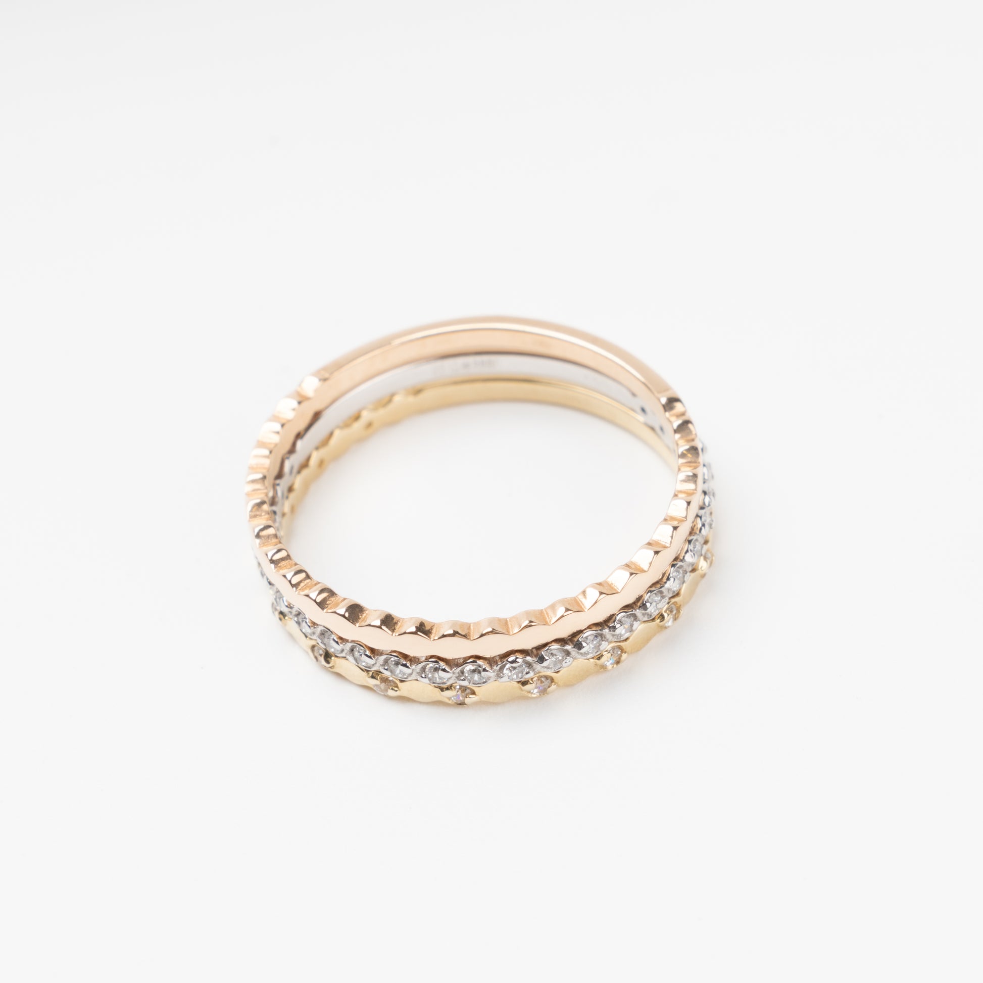 Sophisticated triple stackable ring set in 14K (585) multi-tone gold, featuring a central eternity band of clear zirconias White Gold between two uniquely scalloped Rose and Yellow Gold bands, displayed on a clean white background.
