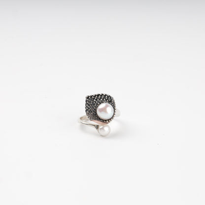 Asymmetrical pearl and dark cubic zirconia ring — front view — Kabluchka