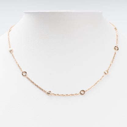 Sophisticated 14K (585) Rose Gold station necklace featuring alternating open round gold links and small bezel-set clear zirconias on a delicate chain, displayed on a white jewelry bust.