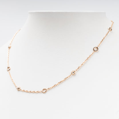 Sophisticated 14K (585) Rose Gold station necklace featuring alternating open round gold links and small bezel-set clear zirconias on a delicate chain, displayed on a white jewelry bust.