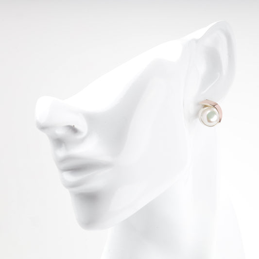 Silver and gold pearl earring worn on ear — Kabluchka