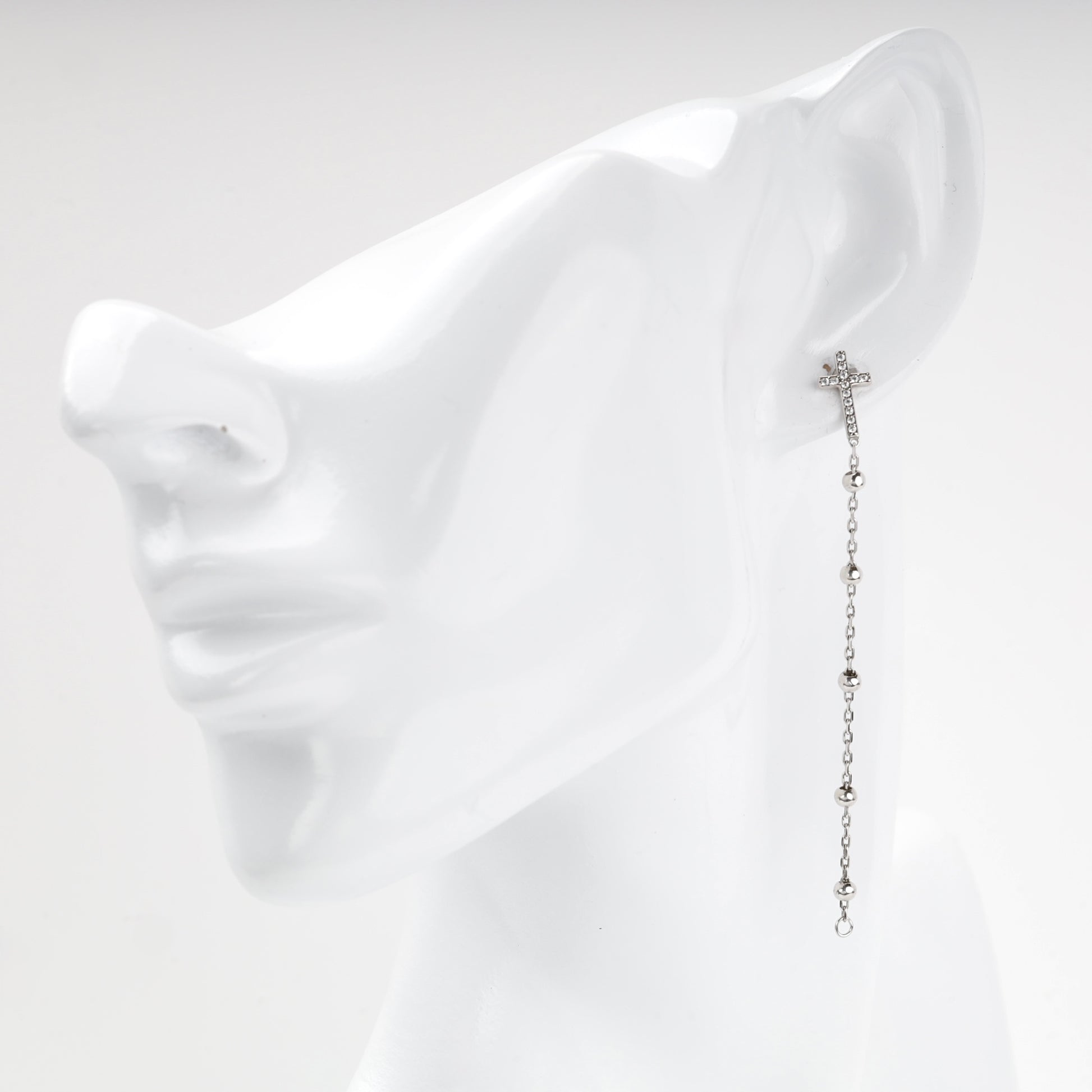 Silver cross drop earring with beaded rosary-style chain shown on the ear — Kabluchka