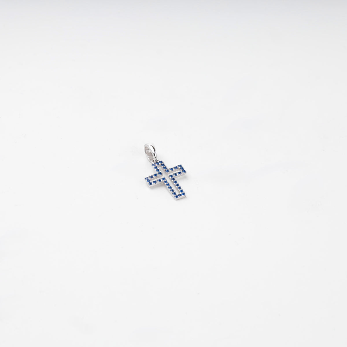 Rhodium-plated silver 925 cross pendant with blue cubic zirconia, detail view