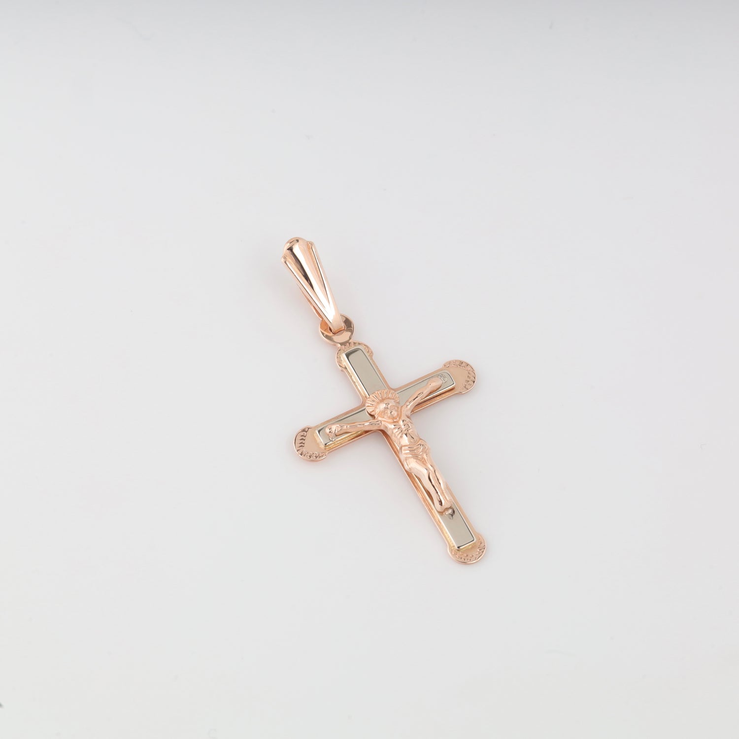 Detailed 14K (585) Rose Gold crucifix pendant featuring a two-tone design with a polished white gold inlay on the cross and a finely crafted figure of Jesus, shown on a clean white background.