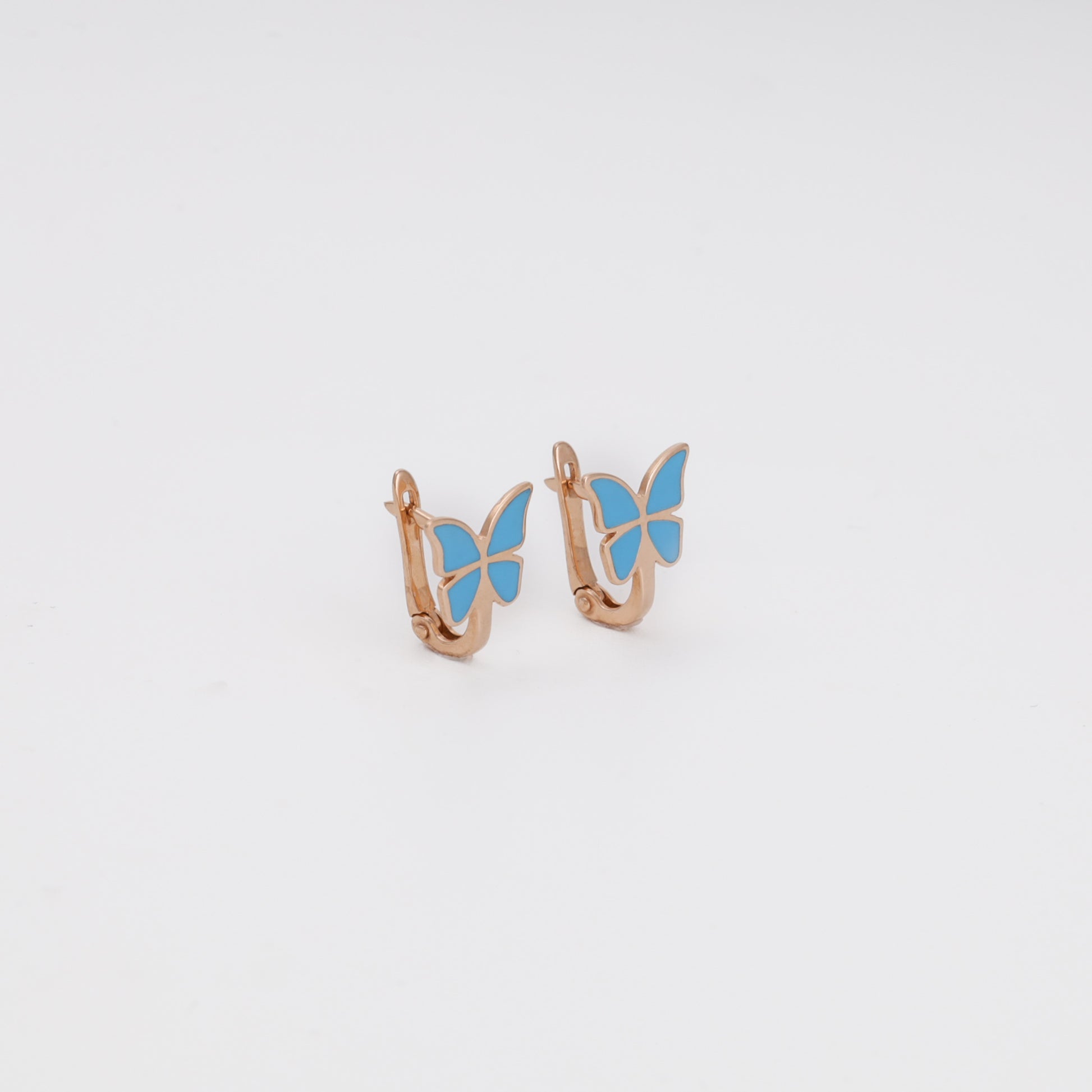 Rose gold butterfly earrings with blue enamel close-up view