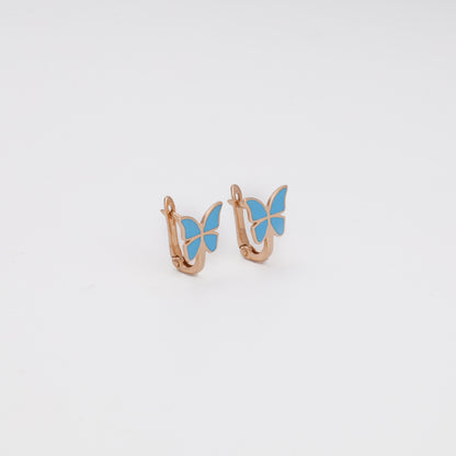 Rose gold butterfly earrings with blue enamel close-up view