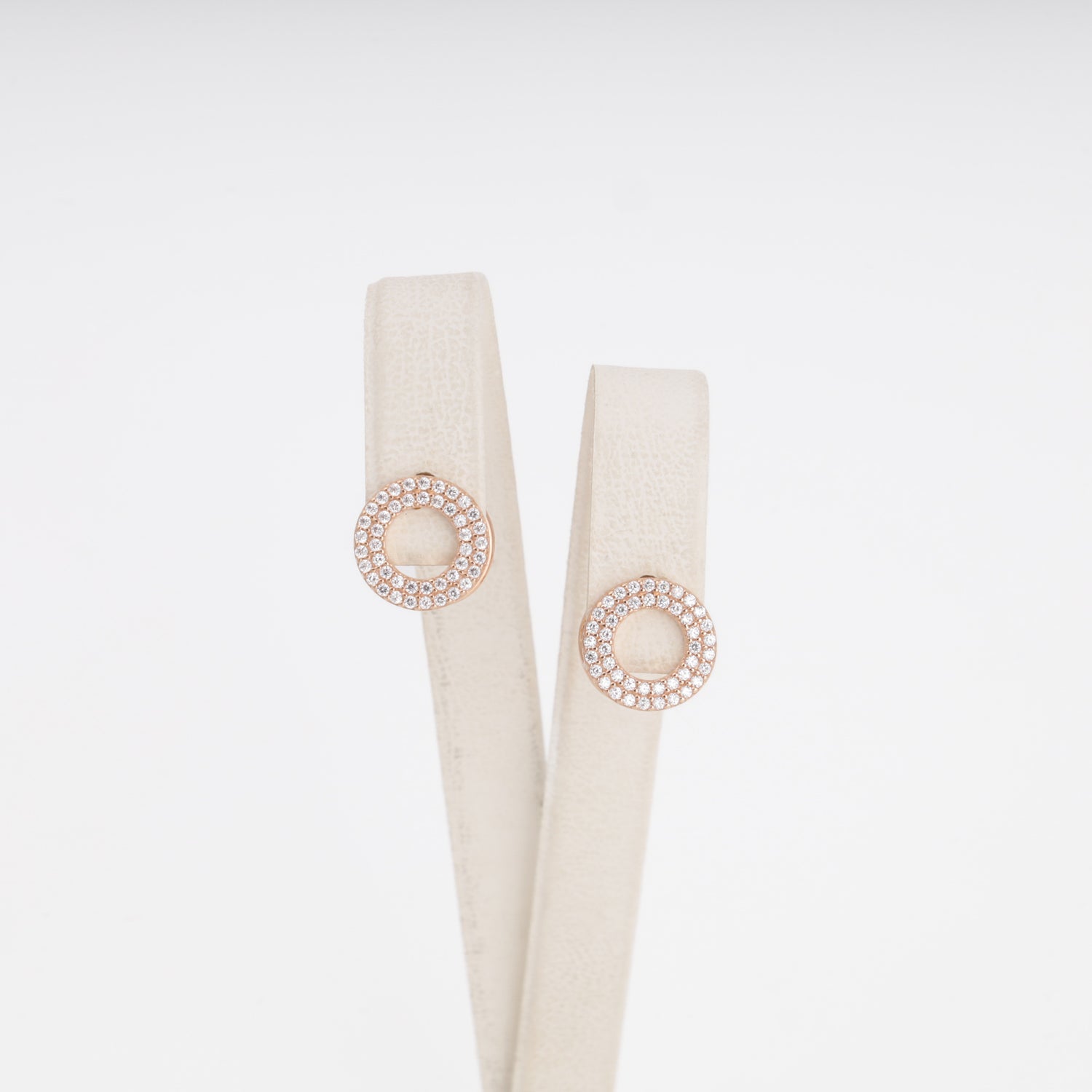 Circular pavé zirconia earrings in 14K rose gold on display stand — Kabluchka Jewelry Store