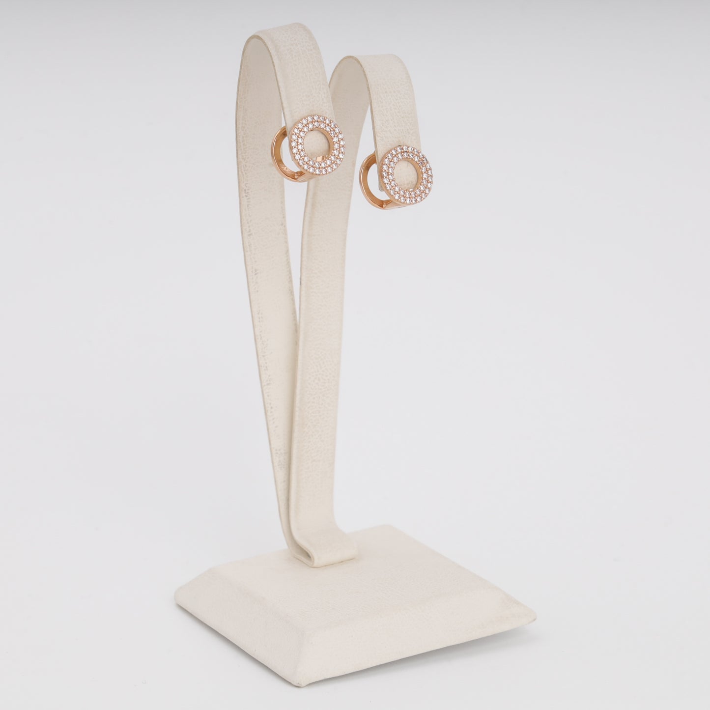 Rose gold circular CZ earrings close-up showing pavé stone setting