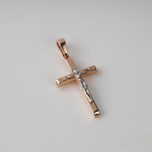Rose gold cross pendant on a light gray background
