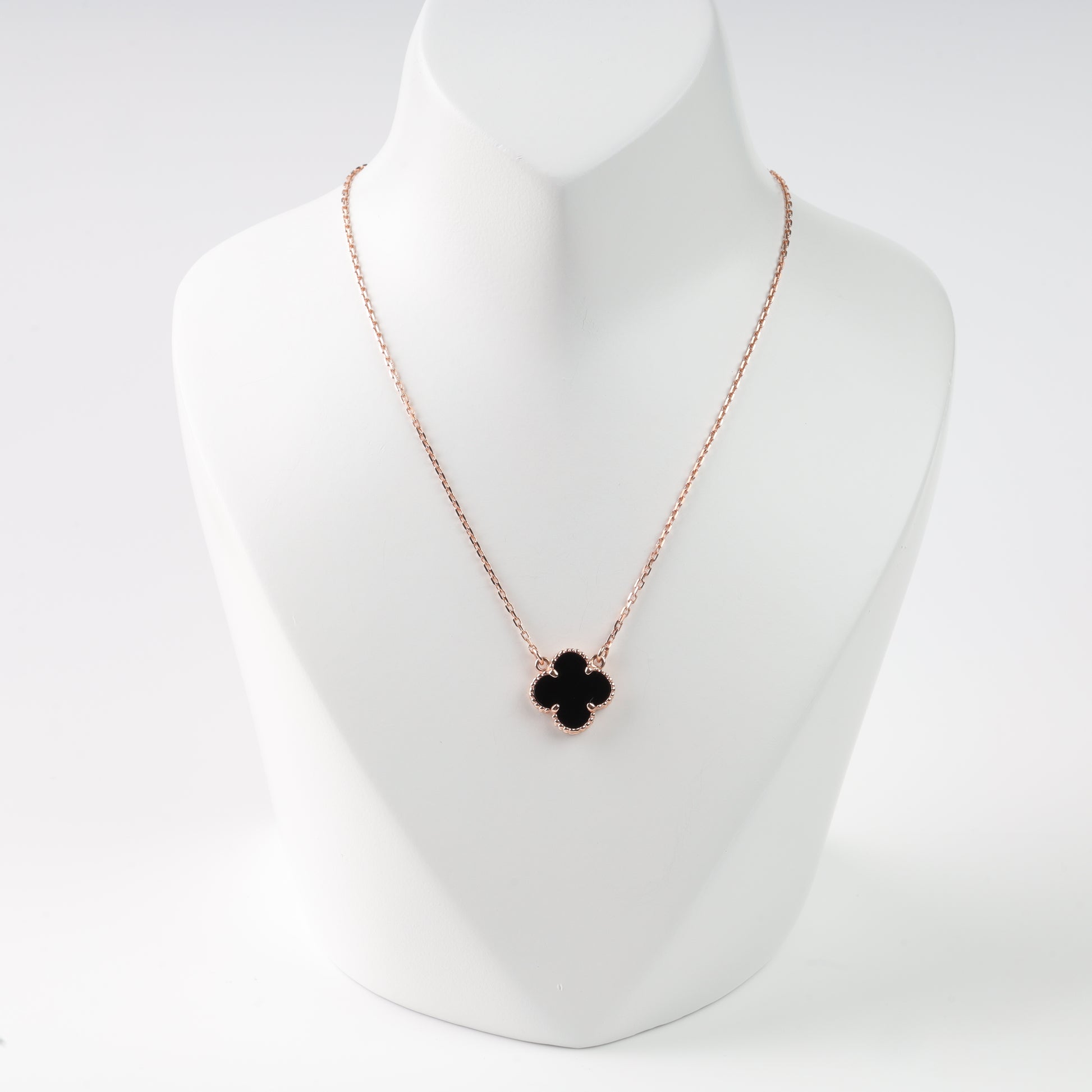 Rose gold 14K (585) necklace with a black onyx four-leaf clover pendant on a white mannequin.