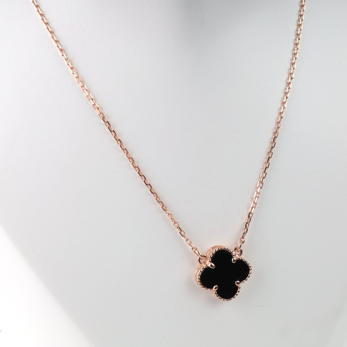 Rose gold 14K (585) necklace with a black onyx four-leaf clover pendant on a white mannequin.