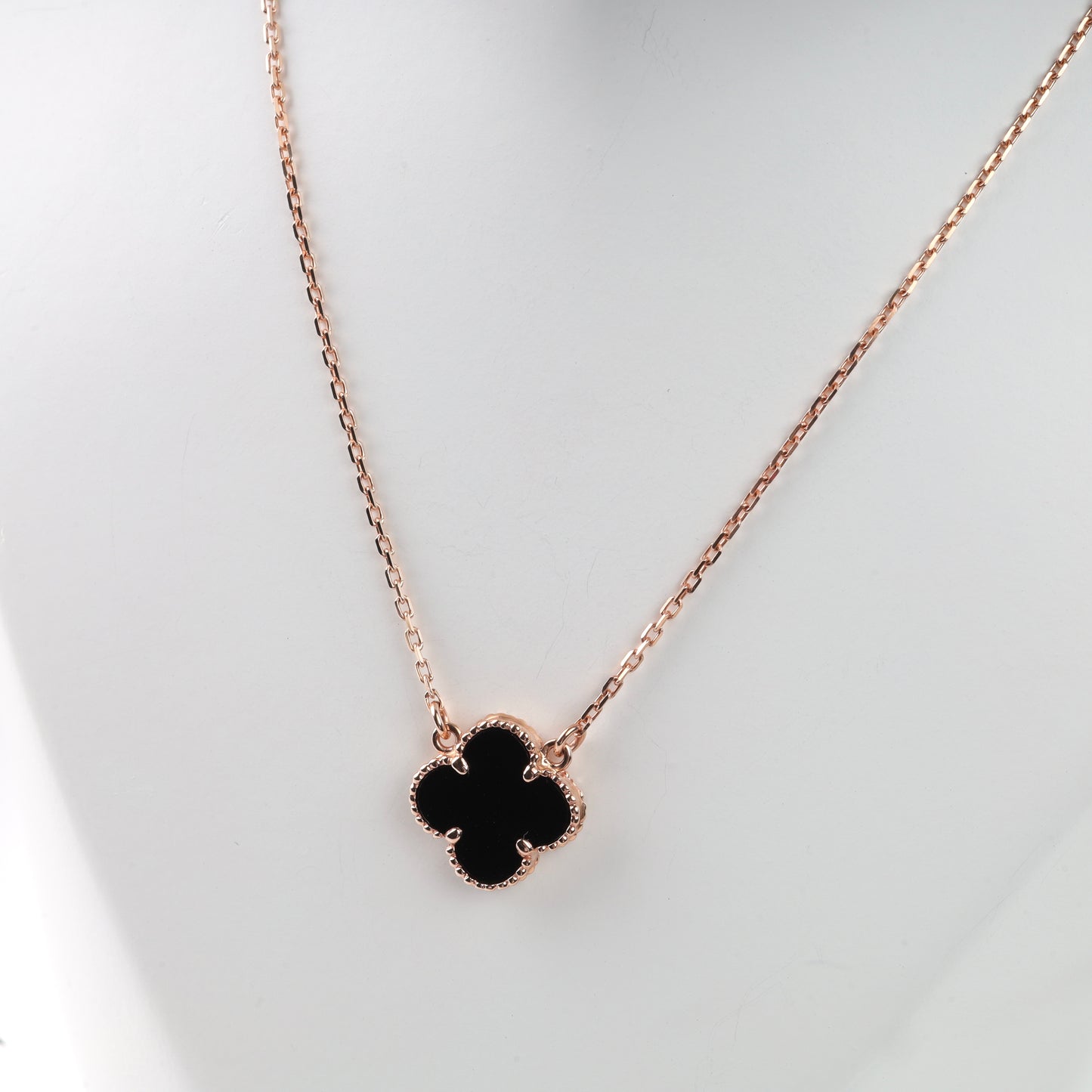 Rose gold 14K (585) necklace with a black onyx four-leaf clover pendant on a white mannequin.