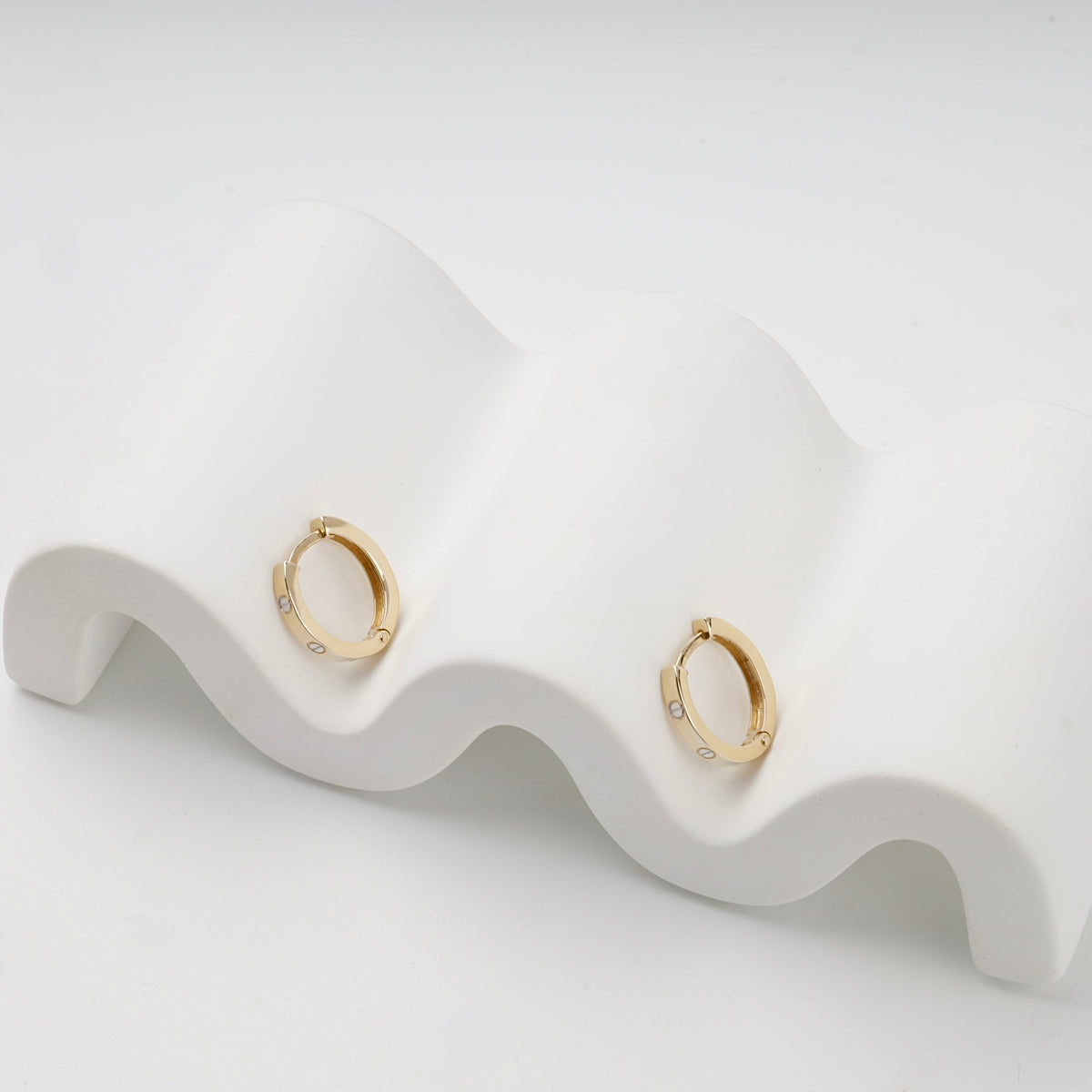 Yellow gold 585 screw motif huggie earrings — angled view — Kabluchka