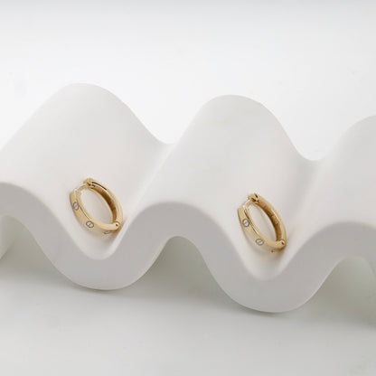 Yellow gold 585 screw motif huggie earrings on display — Kabluchka