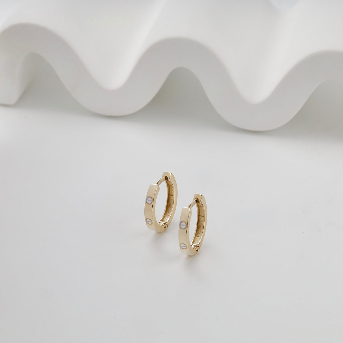 Yellow gold 585 screw motif huggie earrings — front view — Kabluchka