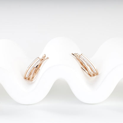 Cubic zirconia triple-band rose gold earrings, angled view