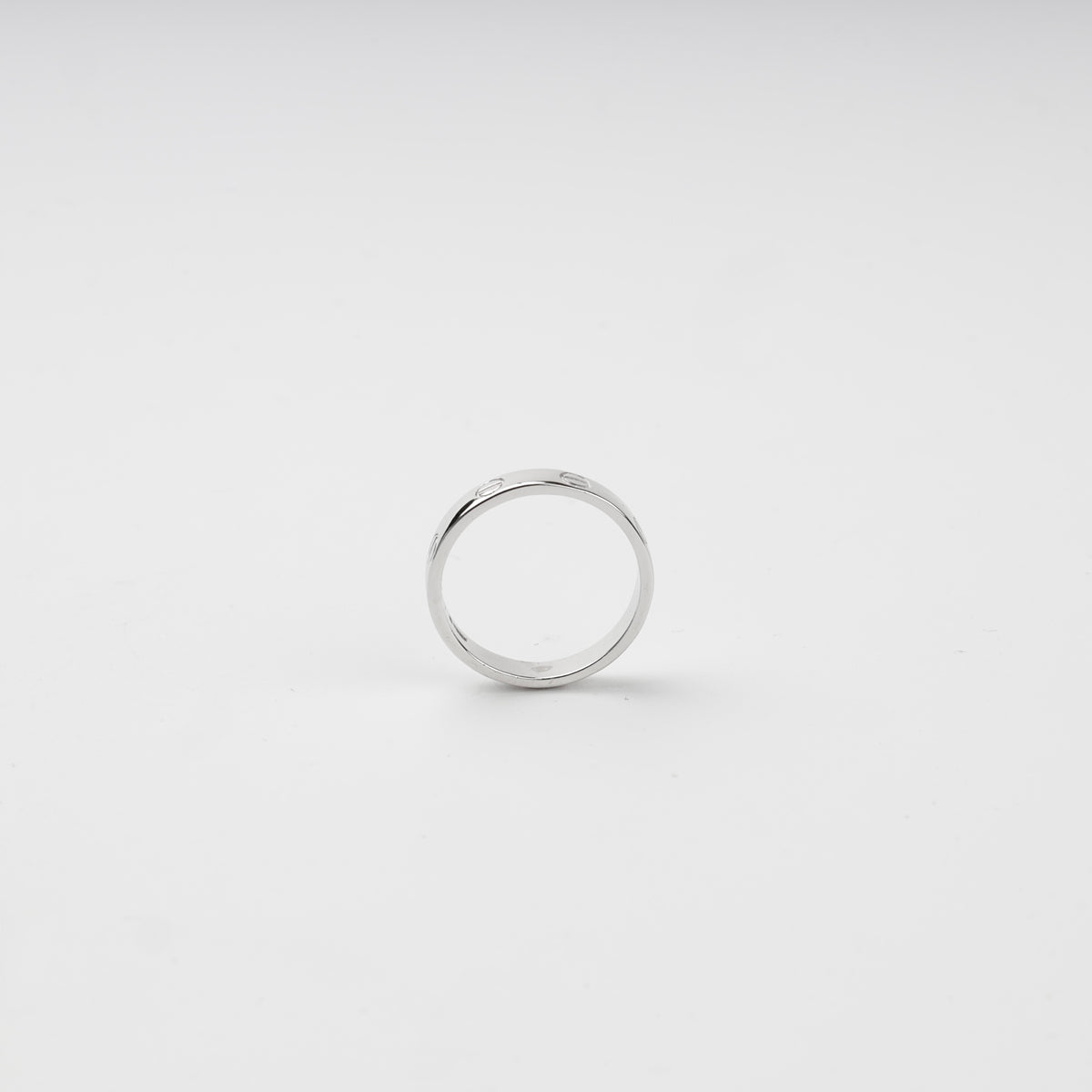 Close-up of engraved screw motifs around the polished silver ring