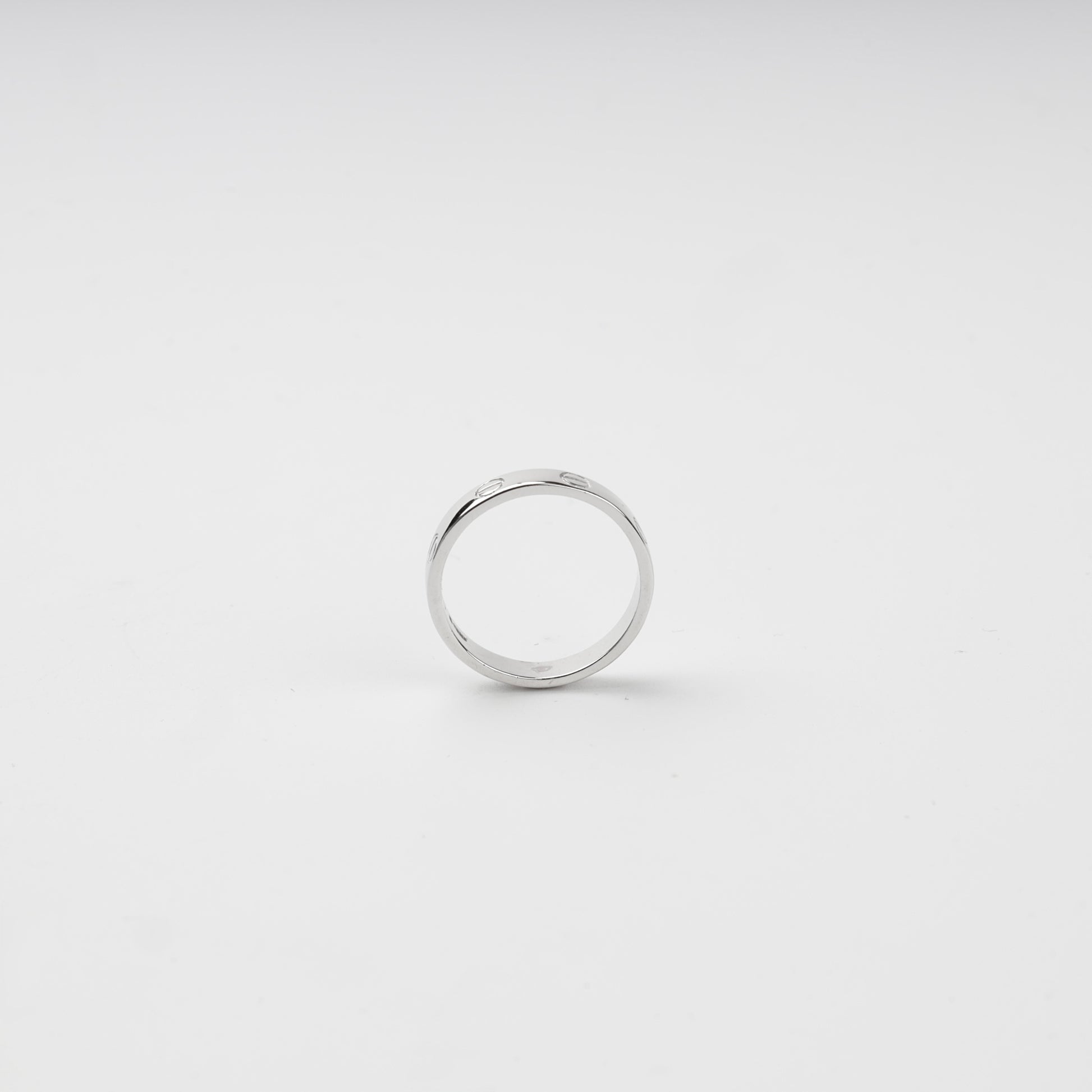 Close-up of engraved screw motifs around the polished silver ring