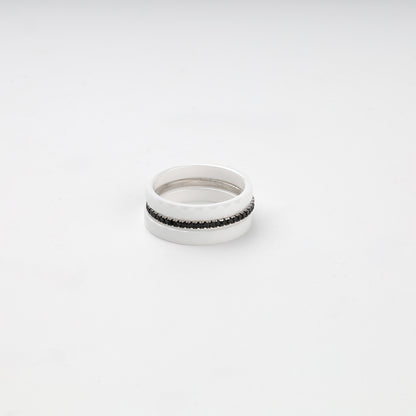 Faceted white ceramic three-ring set with a single row of black cubic zirconia