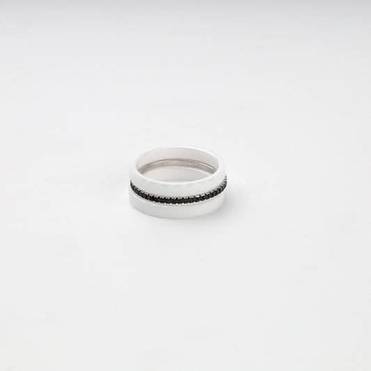 Faceted white ceramic three-ring set with a single row of black cubic zirconia