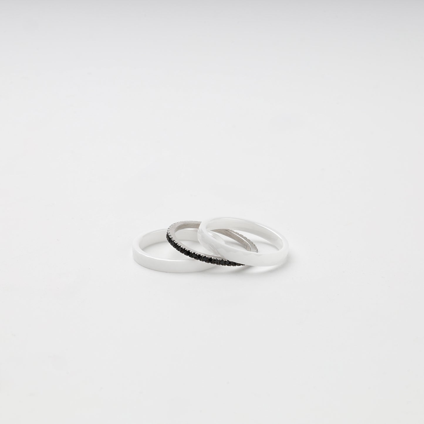 White ceramic ring set arranged around a black cubic zirconia center band