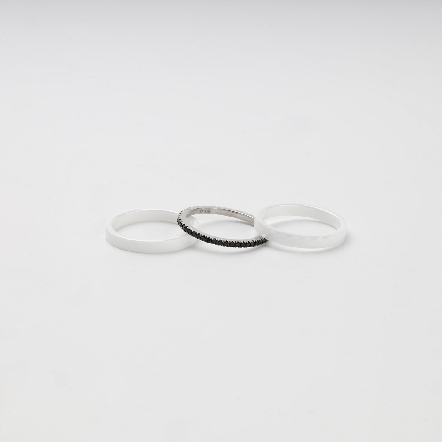 Three separate white ceramic and Silver 925 rings with black cubic zirconia