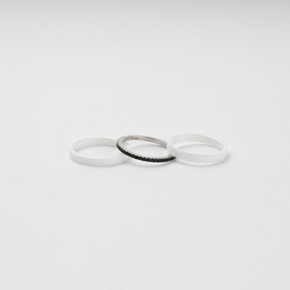 Three separate white ceramic and Silver 925 rings with black cubic zirconia