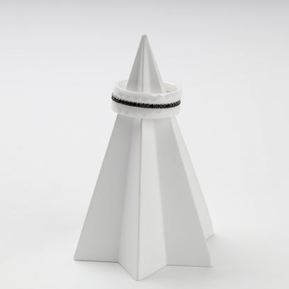 Faceted white ceramic and black cubic zirconia rings in a layered arrangement
