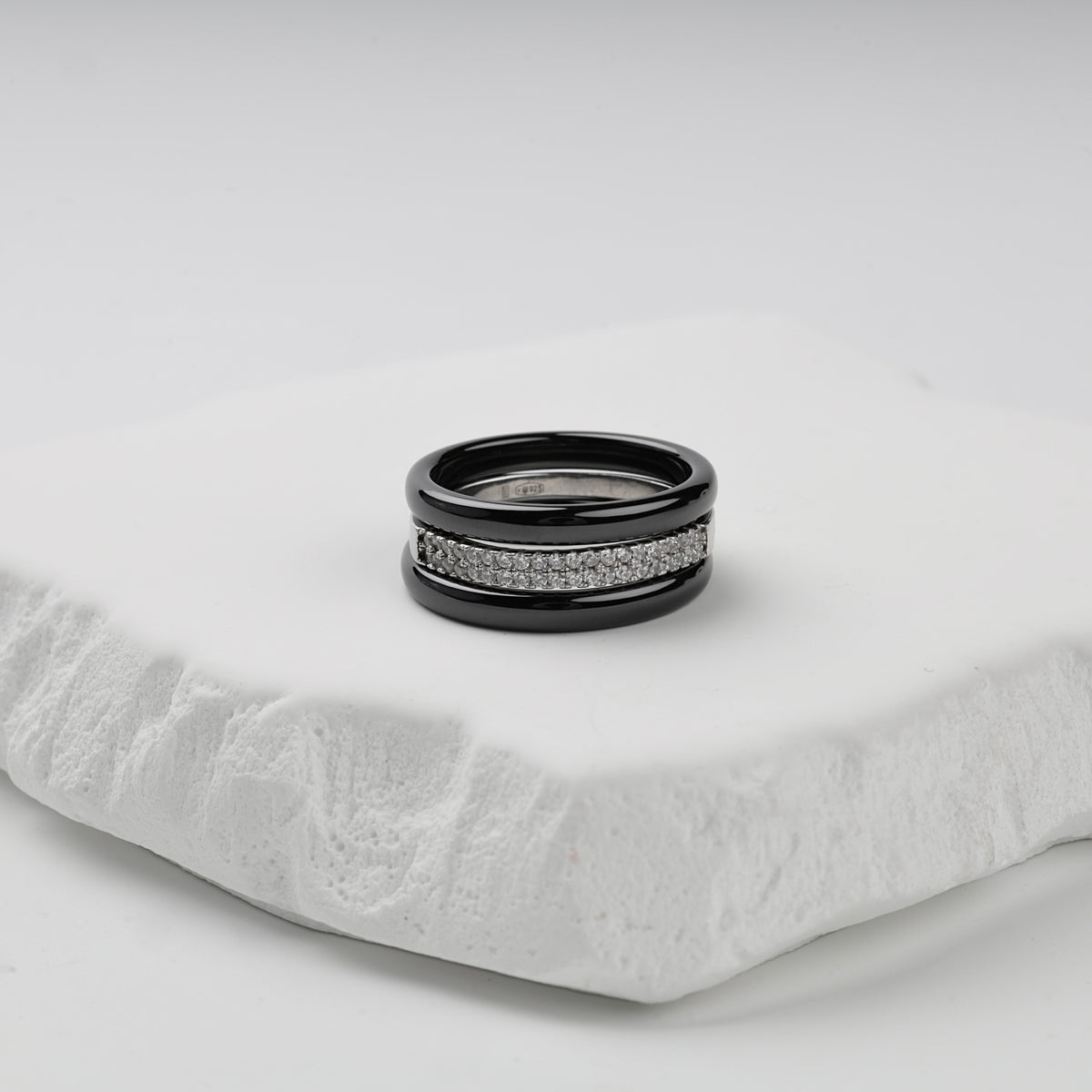 Three-ring set with glossy black ceramic bands and a double row of clear cubic zirconia