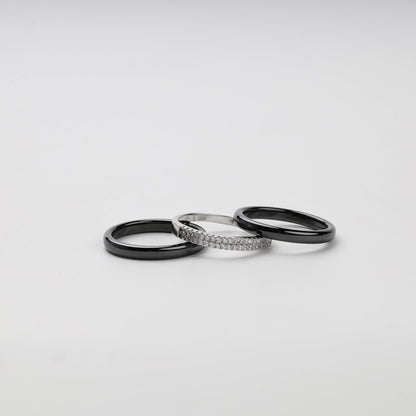 Front angle of a black ceramic three-ring set with clear cubic zirconia