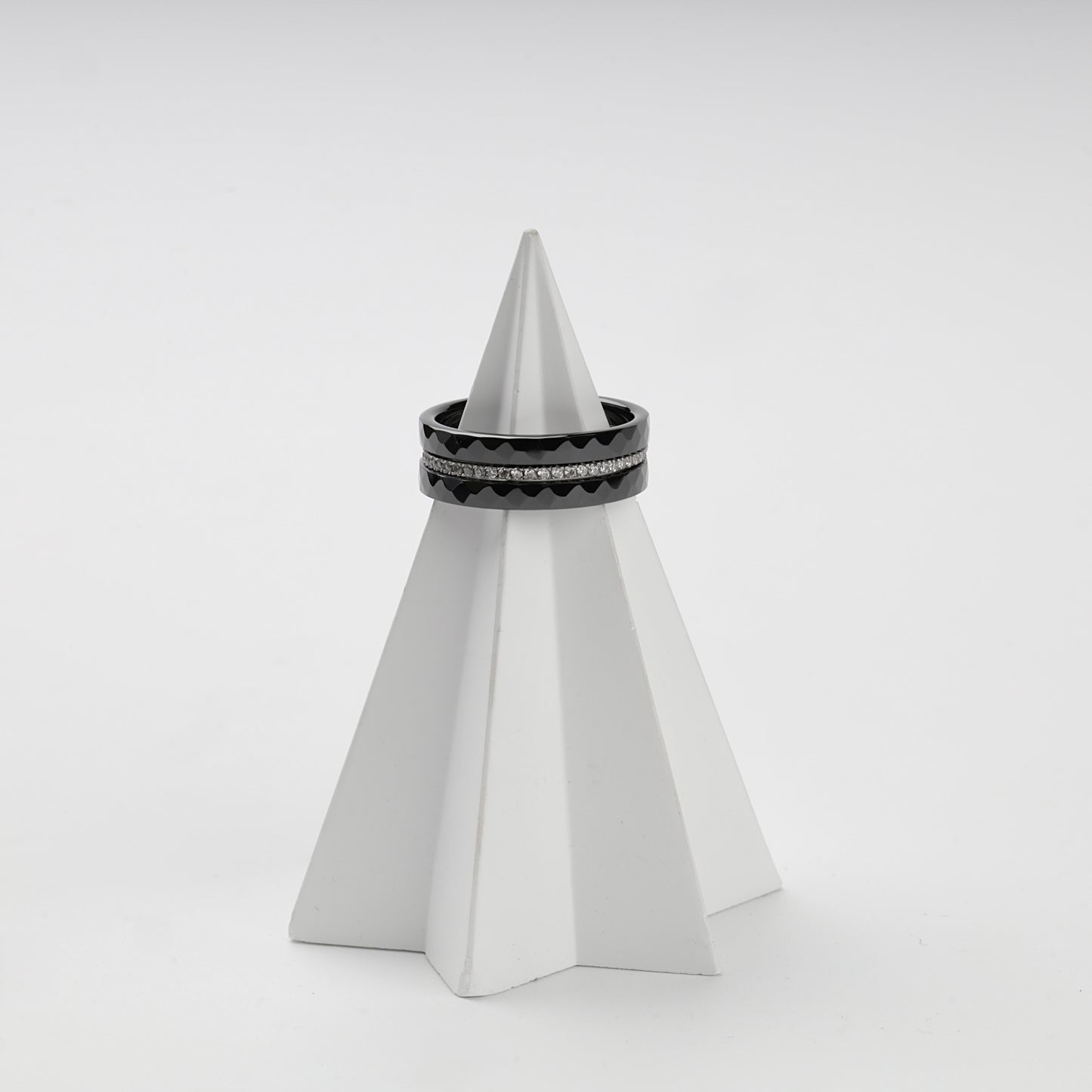 Faceted black ceramic rings stacked around a clear cubic zirconia center row