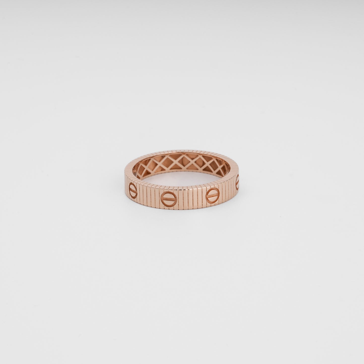 Rose gold ring with screw motif, ribbed band design, 14k gold wedding ring, minimalist Ukrainian Jewelry on white background.