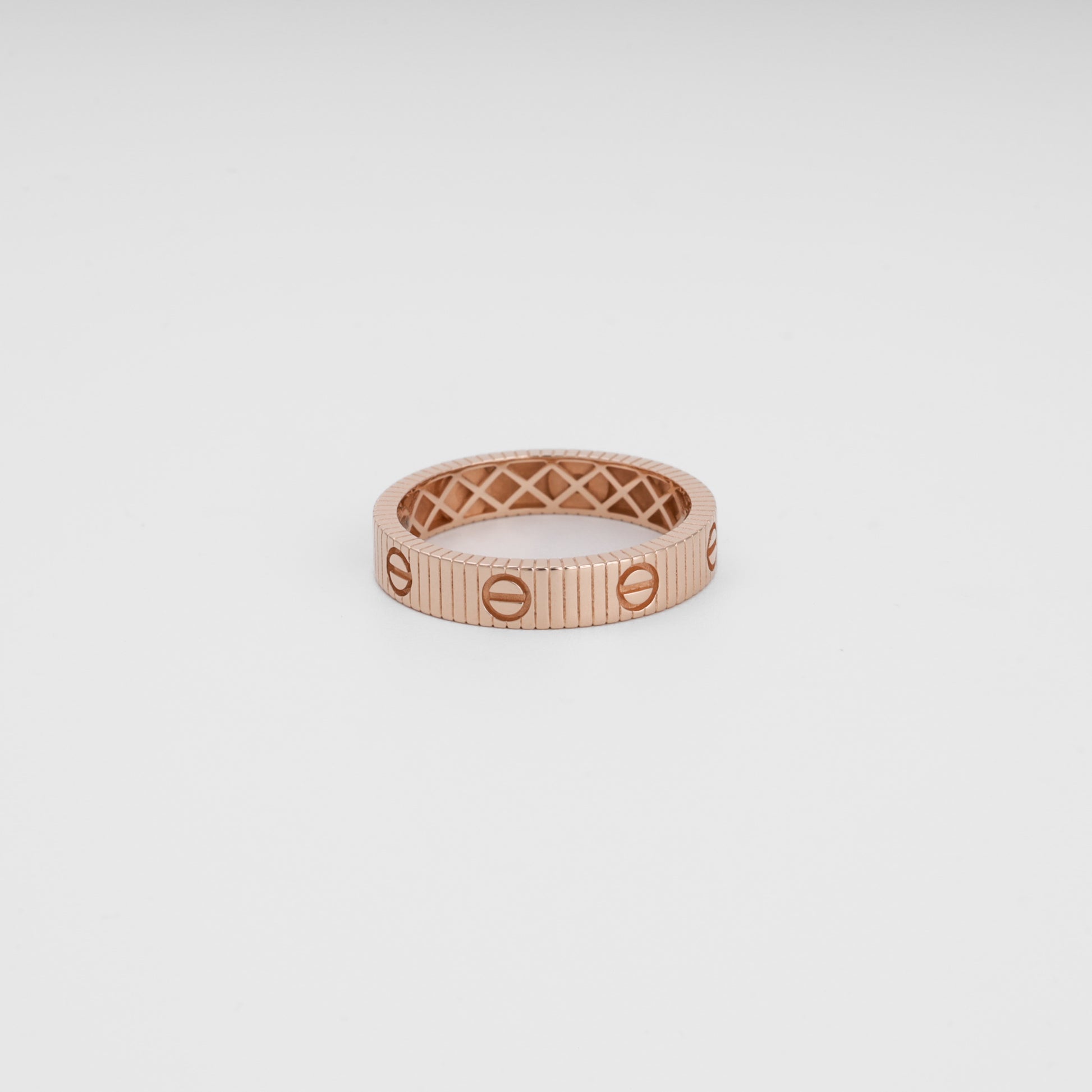 Rose gold ring with screw motif, ribbed band design, 14k gold wedding ring, minimalist Ukrainian Jewelry on white background.